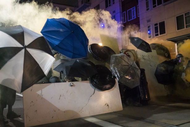 Protesters use umbrellas to block less lethal rounds fired by federal officers during a dispersal at the Immigration and Customs Enforcement detention center in Portland, Ore., on Sept. 18, 2020. (Nathan Howard/Getty Images)