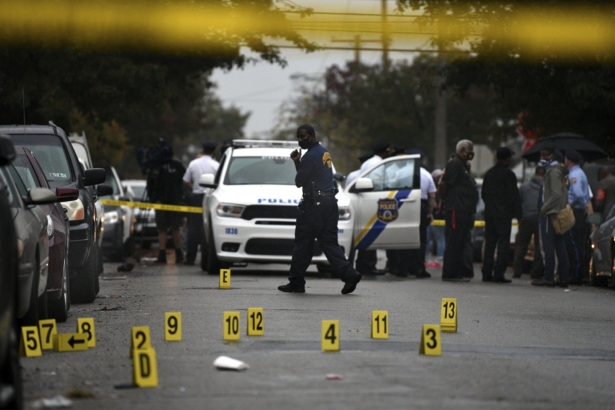 People stand near the scene of a police shooting in Philadelphia on Oct. 26, 2020, after police officers fatally shot a man during a confrontation. (Tom Gralish/The Philadelphia Inquirer via AP)