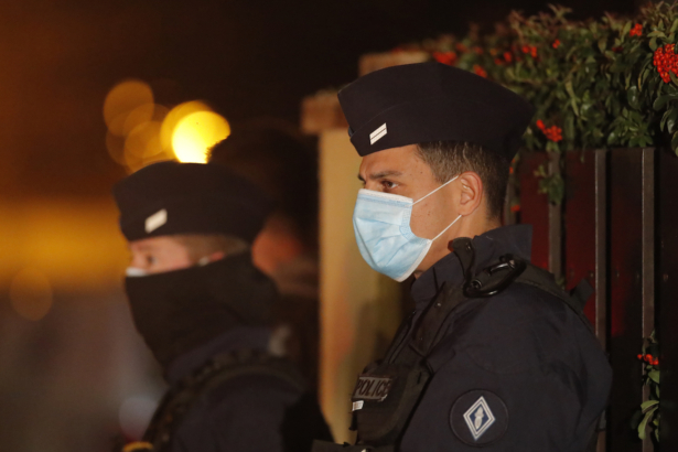 French police officers stand outside a high school after a history teacher who opened a discussion with students on caricatures of Islam's Prophet Muhammad was beheaded in Conflans-Sainte-Honorine, north of Paris, on Oct. 16, 2020. (AP Photo/Michel Euler)