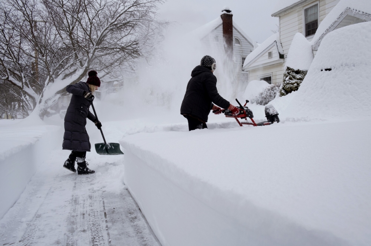 Susan Iannuzzi, left, and Linda Marzell clear a sidewalk after a heavy snowfall on street in Binghamton, N.Y., on Dec. 17, 2020. (Craig Ruttle/AP Photo)