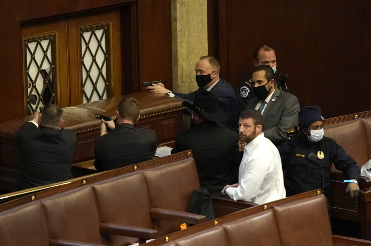 U.S. Capitol police officers point their guns at a door that was vandalized in the House Chamber during a joint session of Congress on January 06, 2021 in Washington, DC. (Drew Angerer/Getty Images)