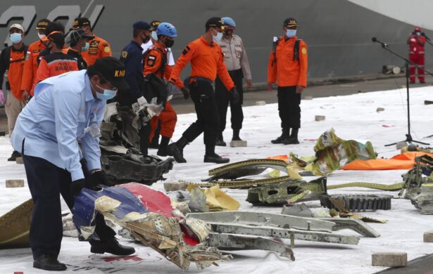 An Indonesian National Transportation Safety Committee (KNKT) investigator inspects the debris found in the waters around the location where Sriwijaya Air passenger jet crashed at Tanjung Priok Port in Jakarta, Indonesia, on Jan. 11, 2021. (Achmad Ibrahim/AP Photo)