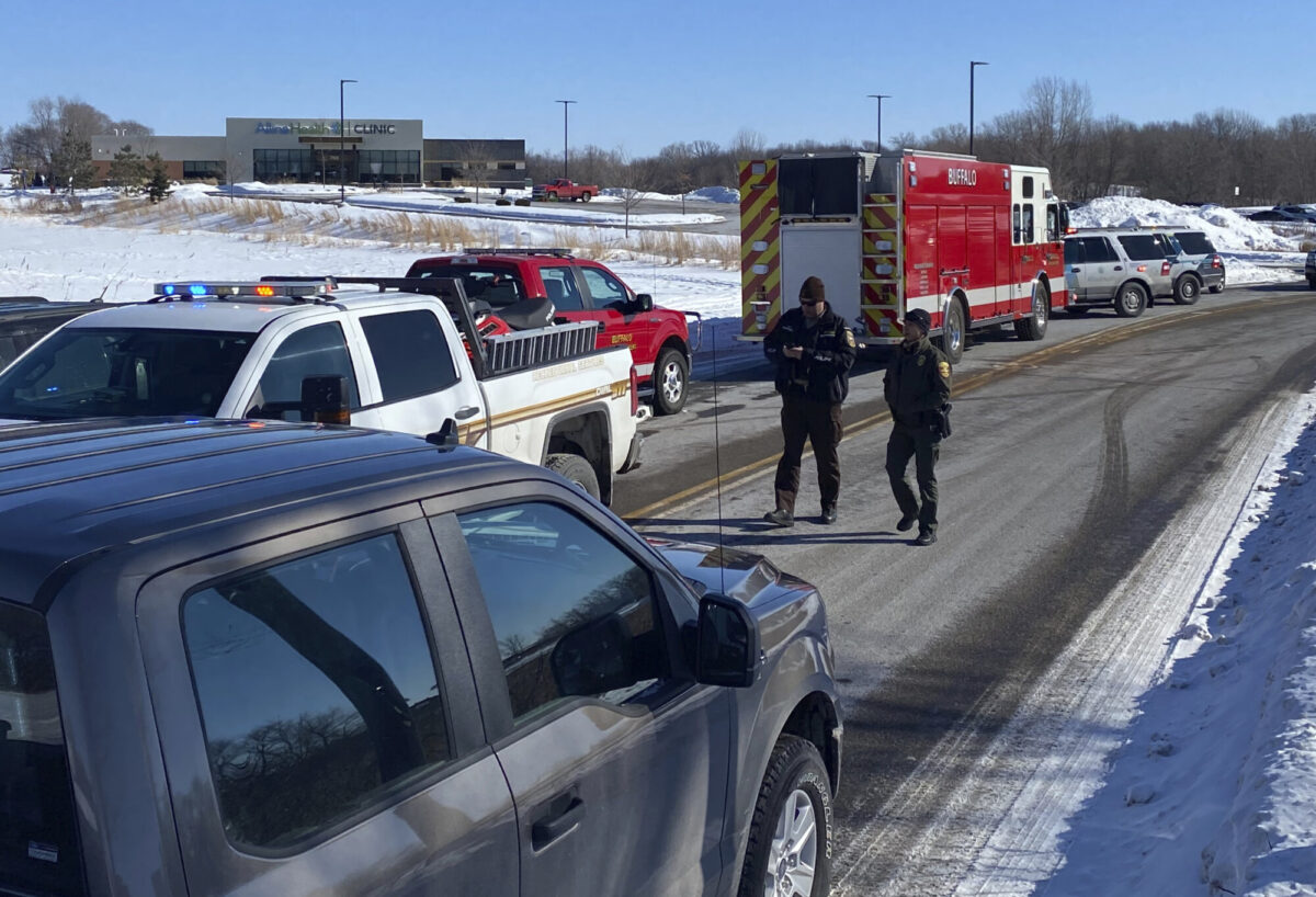 Law enforcement personnel and first responders gather outside of the Allina Health clinic in Buffalo, Minn., on Feb. 9, 2021. (David Joles/Star Tribune via AP)