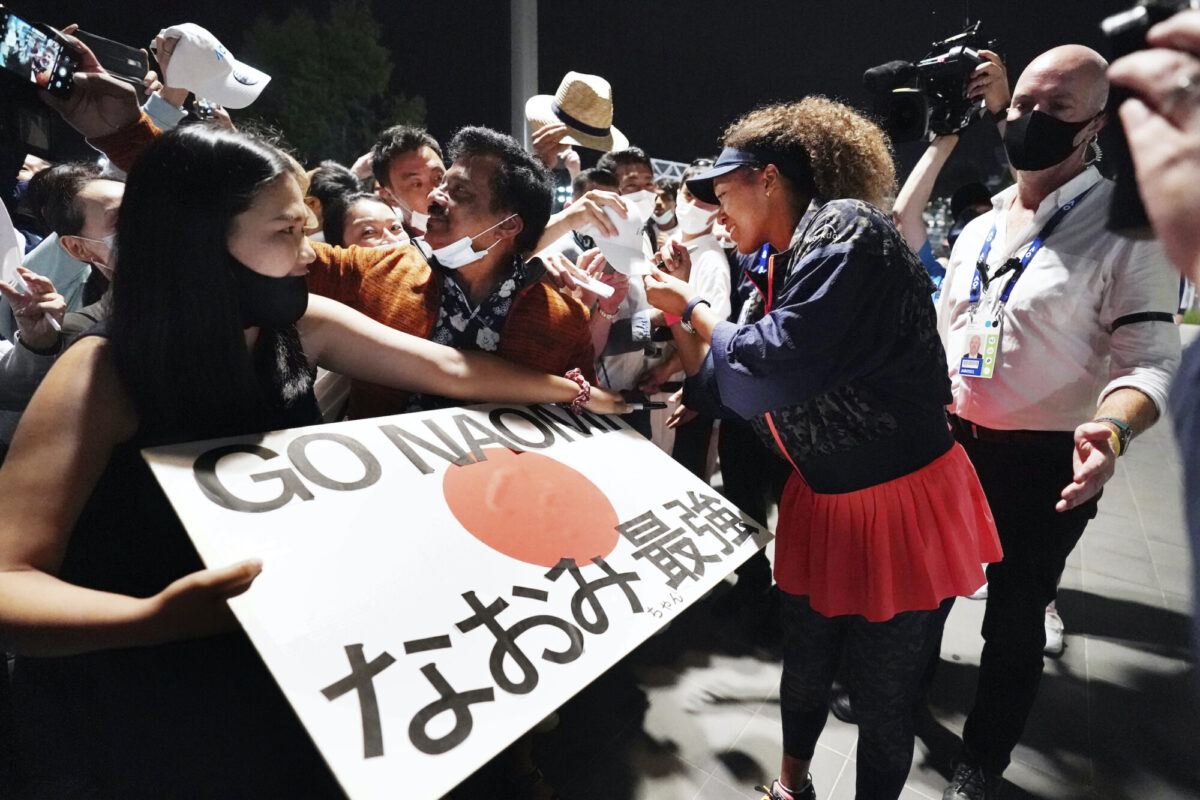 Japan's Naomi Osaka signs autographs after defeating United States' Jennifer Brady in the women's singles final at the Australian Open tennis championship in Melbourne, Australia, Saturday, Feb. 20, 2021. (Michael Dodge/Tennis Australia via AP)