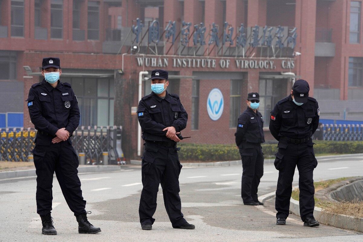 Security personnel gather near the entrance of the Wuhan Institute