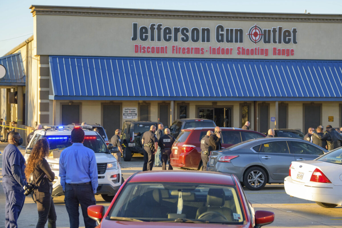 Bystanders react at the scene of a multiple fatality shooting at the Jefferson Gun Outlet in Metairie, La., on Feb. 20, 2021. (AP Photo/Matthew Hinton)