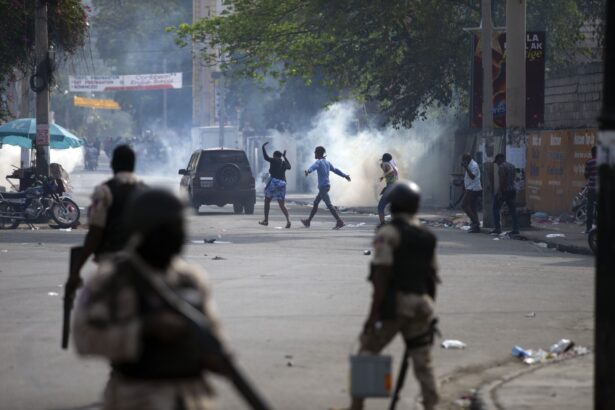 People walk across the street after the police fired tear gas during a nationwide strike demanding the resignation of Haitian President Jovenel Moise in Port-au-Prince, Haiti, on Feb. 2, 2021. (Dieu Nalio Chery/AP Photo)