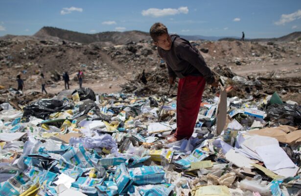 Ronaikel Brito, 16, rummages through empty milk cartons at the Pavia garbage dump on the outskirts of Barquisimeto, Venezuela