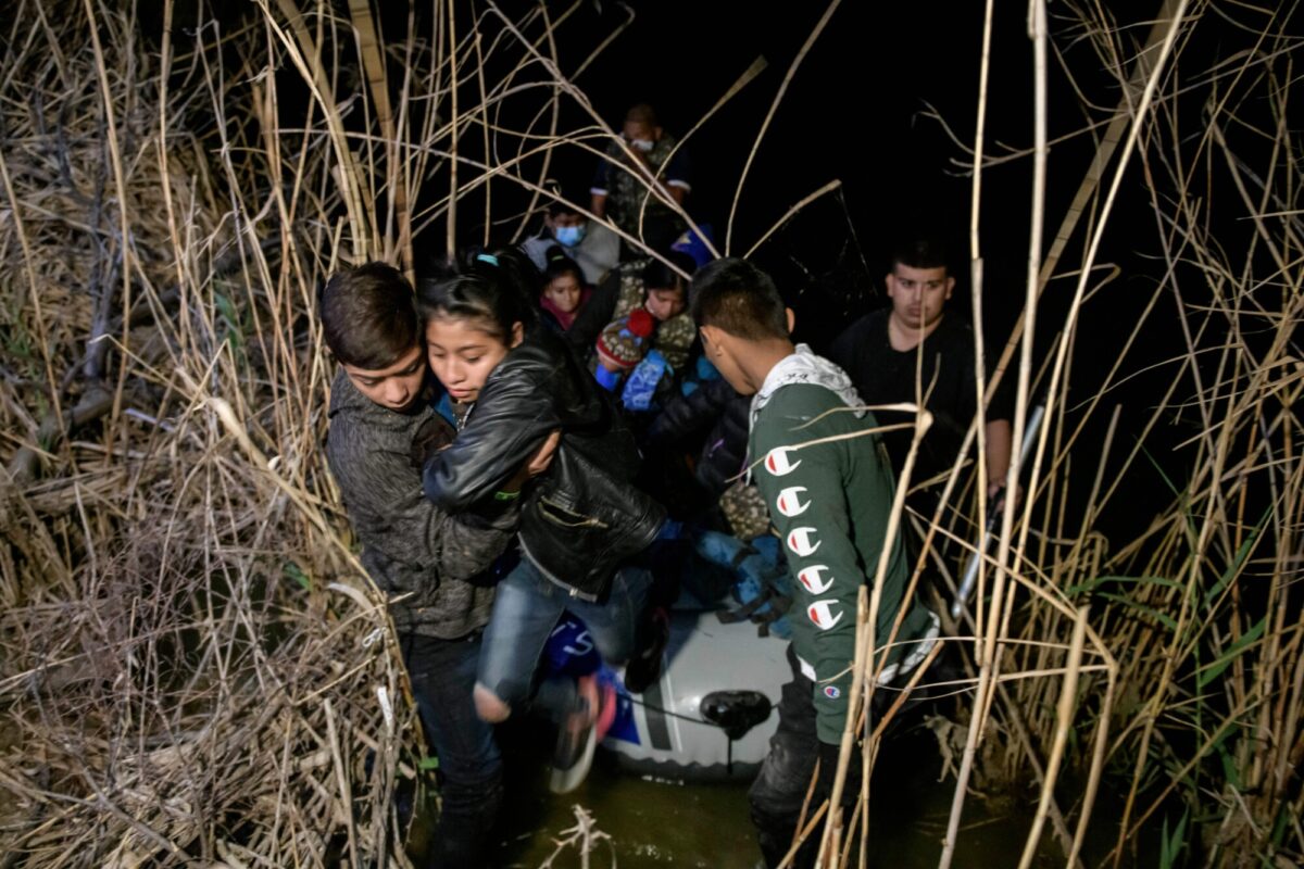 A group of immigrants from Honduras and Guatemala arriving illegally from Mexico disembark from an inflatable boat onto the U.S. side of the Rio Grande river before seeking asylum by turning themselves in to Border Patrol agents at the border city of Roma, Texas, on March 28, 2021. (Ed Jones/AFP via Getty Images)