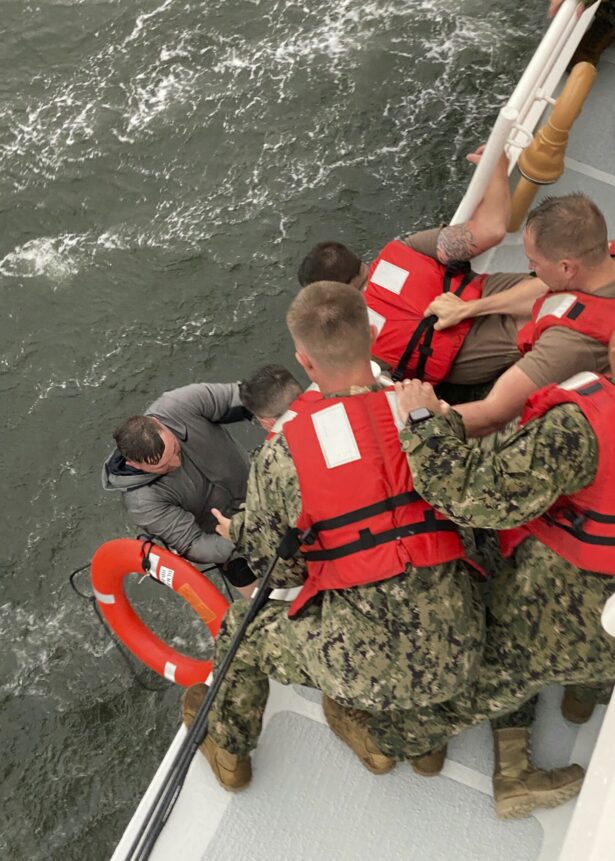 Crew members of the Coast Guard Cutter Glenn Harris pull a person from the water on April 13, 2021, after a 175-foot commercial lift boat capsized 8 miles south of Grand Isle, La. (U.S. Coast Guard via AP)