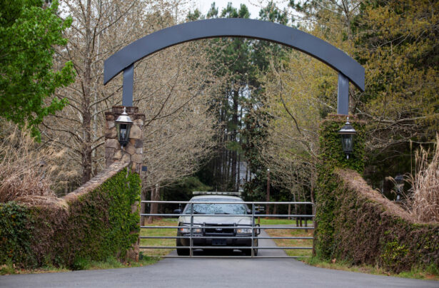 A member of the York County Sheriff's Office guards the entrance to the home where prominent physician Dr. Robert Lesslie, his wife, two grandchildren and another man were shot and killed by former NFL player Phillip Adams in Rock Hill, S.C., on April 8, 2021. (Sam Wolfe/Reuters)