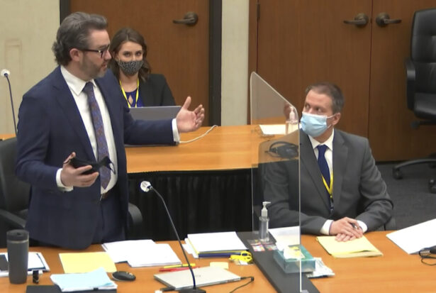 Defense attorney Eric Nelson (L) discusses motions before the court as defendant, former Minneapolis police officer Derek Chauvin (R), and Nelson's assistant Amy Voss (rear) listen as Hennepin County Judge Peter Cahill presides over the trial of Chauvin at the Hennepin County Courthouse in Minneapolis, Minn., on April 12, 2021. (Court TV via AP/Pool)