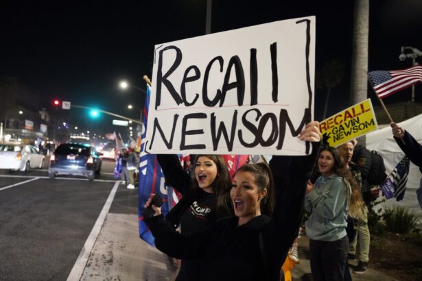 Demonstrators shout slogans while carrying a sign calling for a recall on Gov. Gavin Newsom during a protest against a stay-at-home order amid the COVID-19 pandemic in Huntington Beach, Calif., on Nov. 21, 2020. (Marcio Jose Sanchez/AP Photo)