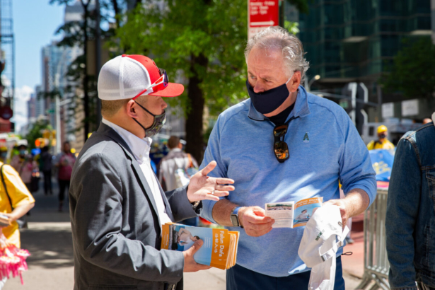 Bystanders watch a parade by practitioners of the spiritual discipline Falun Gong in New York on May 13, 2021. (Chung I Ho/The Epoch Times)