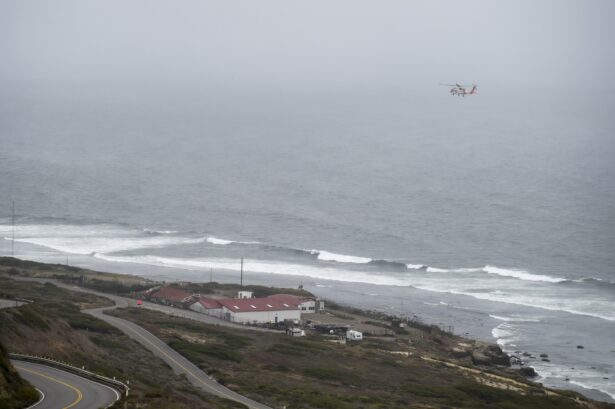A U.S. Coast Guard helicopter flies over boats searching the area where a boat capsized just off the San Diego coast, Calif., on May 2, 2021. (Denis Poroy/AP Photo)
