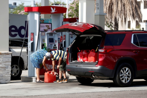A couple fills up multiple 5 gallon gas tanks at a Wawa gas station, after a cyberattack crippled the biggest fuel pipeline in the country, run by Colonial Pipeline, in Tampa, Fla., on May 12, 2021. (Octavio Jones/Reuters)