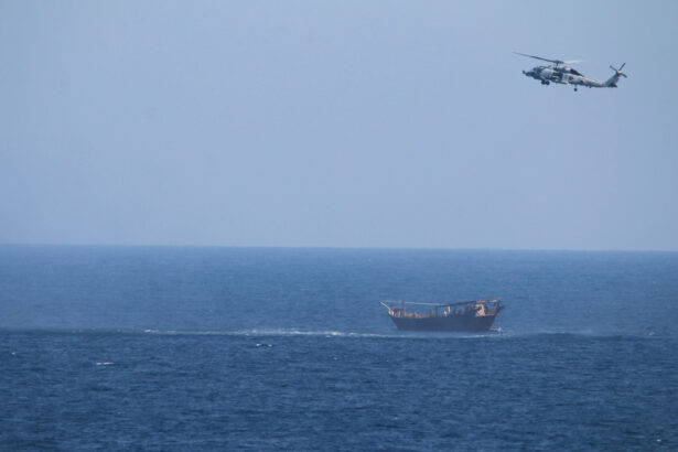 A U.S. Navy Seahawk helicopter flies over a stateless dhow later found to be carrying a hidden arms shipment in the Arabian Sea, on May 6, 2021. (U.S. Navy via AP)