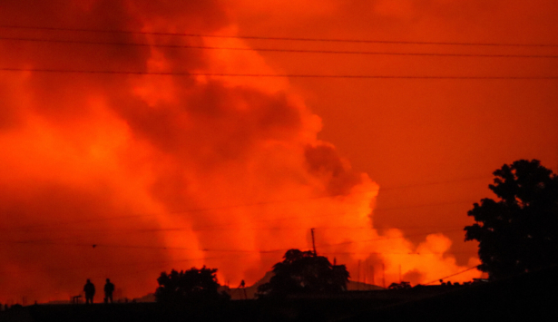 Two people are seen silhouetted against a night sky turned red by the eruption of Mount Nyiragongo, in Goma, Congo, on May 22, 2021. (Justin Kabumba/AP Photo)