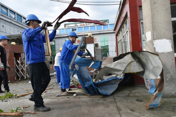 Workers clear debris at a factory that was damaged by a reported tornado in Shengze township in Suzhou in eastern China's Jiangsu Province, China, on May 15, 2021. (Chinatopix via AP)