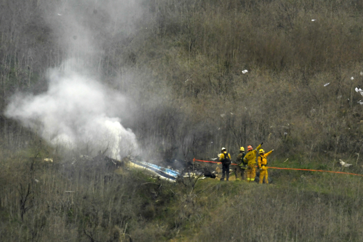 In this file photo firefighters work the scene of a helicopter crash where former NBA basketball star Kobe Bryant died, in Calabasas, Calif., on Jan. 26, 2020. (Mark J. Terrill/AP Photo, File)