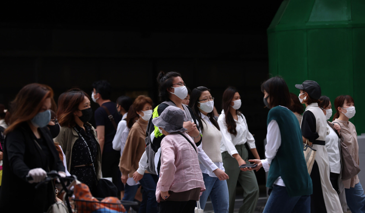 Pedestrians wear protective face masks as they cross the road at Umeda commercial and entertainment district in Osaka, Japan, on May 28, 2021. (Buddhika Weerasinghe/Getty Images)
