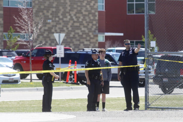 Police stand with a youth outside Rigby Middle School following a shooting there, in Rigby, Idaho, on May 6, 2021. (AP Photo/Natalie Behring)