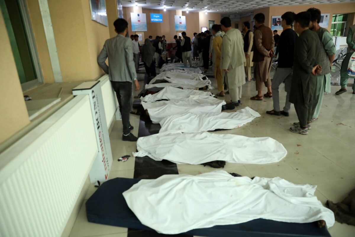 Afghan men try to identify the dead bodies at a hospital after a bomb explosion near a school west of Kabul, Afghanistan, on May 8, 2021. (Rahmat Gul/AP Photo)