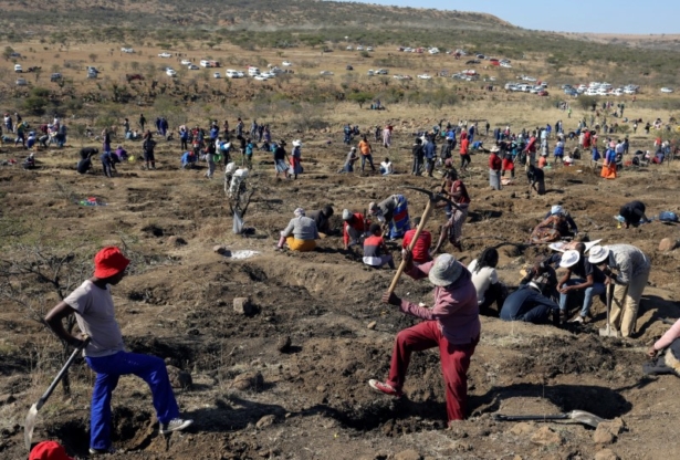 A man uses a pickaxe to dig as fortune seekers flock to the village after pictures and videos were shared on social media showing people celebrating after finding what they believe to be diamonds, in the village of KwaHlathi outside Ladysmith, in KwaZulu-Natal province, South Africa, on June 14, 2021. (Siphiwe Sibeko/Reuters)