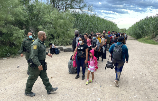 A group of Venezuelans wait to be picked up by Border Patrol after illegally crossing the Rio Grande from Mexico into Del Rio, Texas, on June 3, 2021. (Charlotte Cuthbertson/The Epoch Times)