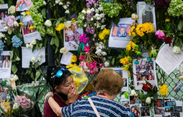 Mourners visit the makeshift memorial near the site of the collapsed condominium in Surfside, Fla., on June 29, 2021. (Matias J. Ocner/Miami Herald via AP)