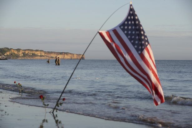 World War II reenactors stand in the sea on Omaha Beach in Saint-Laurent-sur-Mer, Normandy, France, on June, 6 2021. (David Vincent/AP Photo)