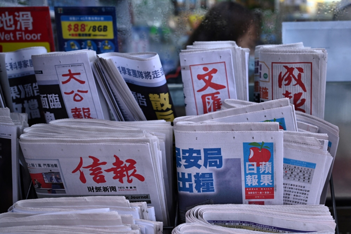 The daily edition of the Apple Daily newspaper (R-middle row) is seen displayed amongst other local papers outside a convenience store in Hong Kong, on June 22, 2021. (Anthony Wallace/AFP via Getty Images)