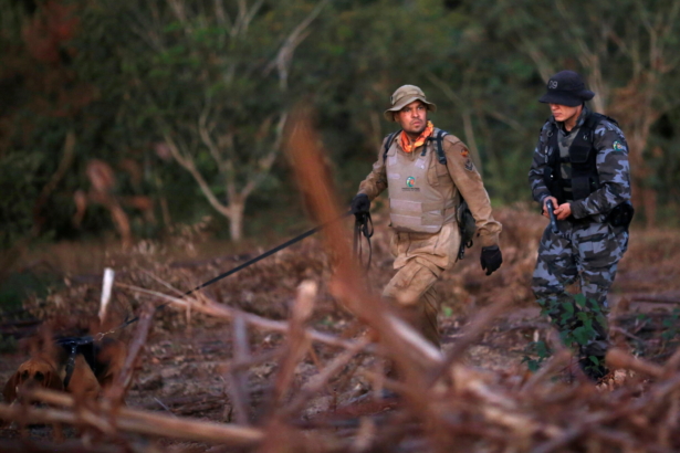 Police officers with a K-9 dog participate in a manhunt for suspected serial killer in Cocalzinho de Goias, Goias state, Brazil, on June 22, 2021. (Adriano Machado/Reuters)