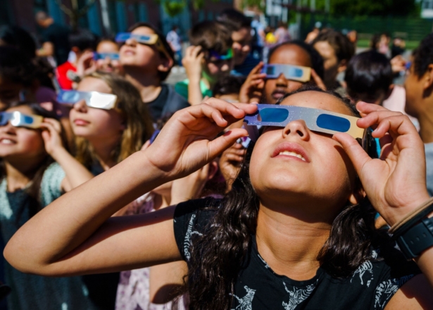 Pupils, wearing protective glasses, look at the partial solar eclipse in Schiedam, Netherlands, on June 10, 2021. (Marco De Swart/ANP/AFP via Getty Images)