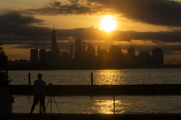 The New York skyline is seen as the Moon partially covers the sun during a partial solar eclipse seen from Jersey City, N.J., on June 10, 2021. (Kena Betancur/AFP via Getty Images)