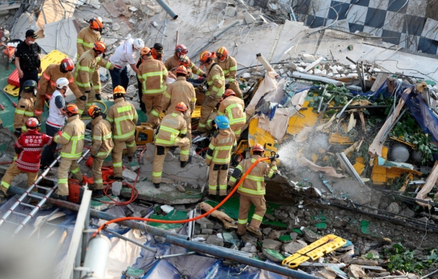 Firefighters search for survivors from a collapsed building in Gwangju, South Korea, on June 9, 2021. (Chung Hoi-sung/Yonhap via AP)