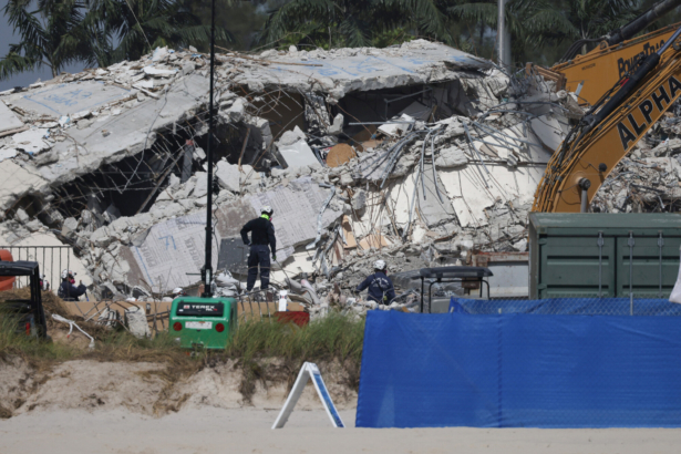 Rescue workers watch as excavators are used to dig through the rubble of the collapsed 12-story Champlain Towers South condo building in Surfside, Fla., on July 9, 2021. (Anna Moneymaker/Getty Images)