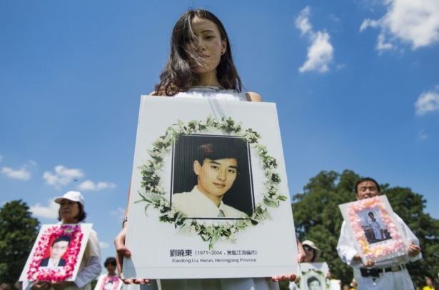 Falun Gong demonstrators hold memorial pictures as they march on Capitol Hill in Washington, DC, July 17, 2014, as part of the events sponsored by the Falun Dafa Association of Washington, DC, to end "Chinese persecution of Falun Gong practitioners". AFP PHOTO / Jim WATSON (Photo credit should read JIM WATSON/AFP via Getty Images)