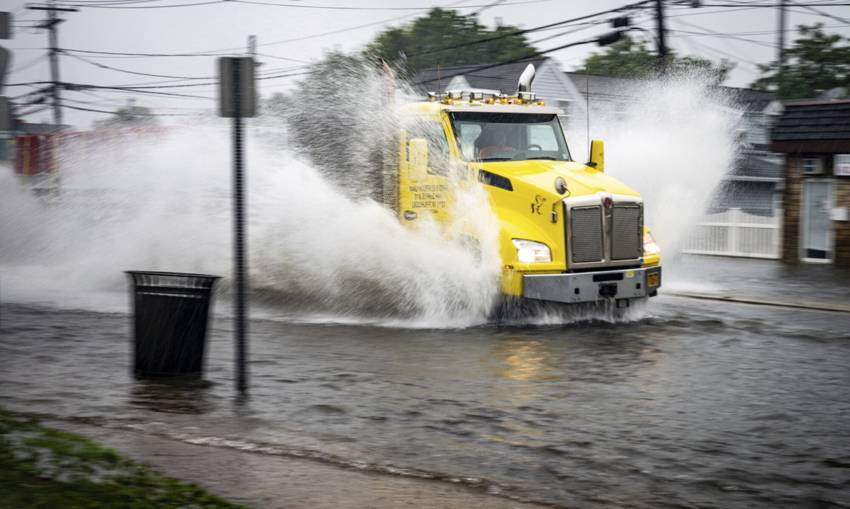 A truck makes its way through the flooding caused by Tropical Storm Elsa on Wellwood Avenue on July 9, 2021, in Lindenhurst, N.Y. (J. Conrad Williams Jr./Newsday via AP)