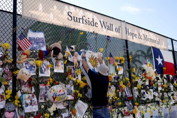Bernardo Camou Font places an Uruguayan flag at the memorial site for victims of the collapsed 12-story Champlain Towers South condo building in Surfside, Fla., on July 8, 2021. (Anna Moneymaker/Getty Images)