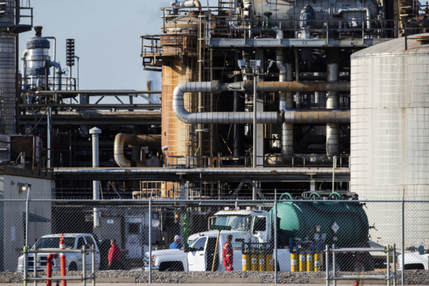 Workers stand in a lot at a LyondellBasell facility in La Porte, Texas, on July 27, 2021. (Mark Mulligan/Houston Chronicle via AP)