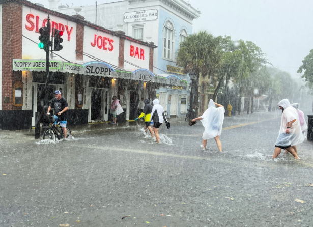 Determined visitors head for Sloppy Joe's Bar while crossing a flooded Duval Street as heavy winds and rain pass over Key West, Fla., on July 6, 2021. (Rob O'Neal/The Key West Citizen via AP)
