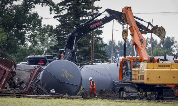 Crews work to clean up a spill after the derailment of a 20-car train carrying tar sands and lumber near Blackfalds, Alta., Canada, on July 3, 2021. (Jeff McIntosh/The Canadian Press via AP)