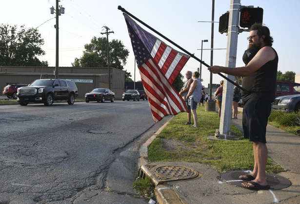 Community members show their support as they stand along the sidewalk as a fallen officer procession makes its way past the Terre Haute Police Department in Terre Haute, Ind., on July 7, 2021. (Joseph C. Garza/The Tribune-Star via AP)