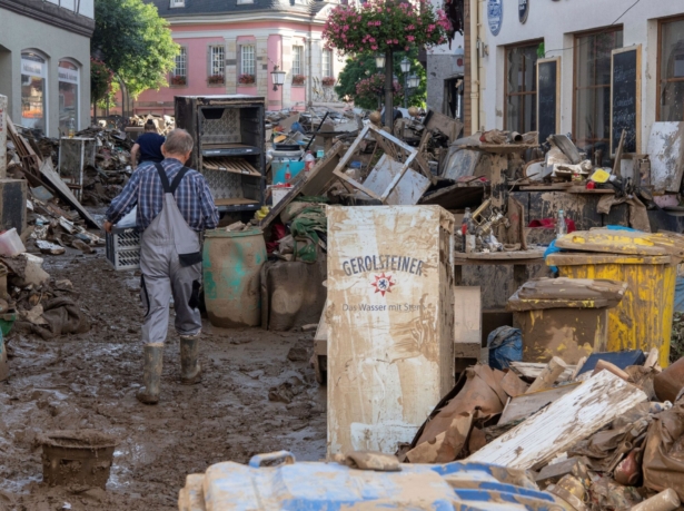 Residents walk through rubbish and piled up furnishings from the destroyed houses and apartments in downtown Ahrweiler, western Germany, on July 18, 2021. (Boris Roessler/dpa via AP)