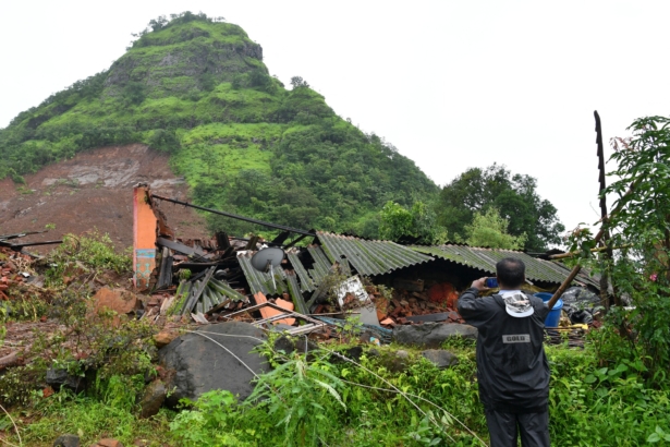 A man takes pictures of a landslide at Taliye, about 22 km from Mahad city, India, on July 24, 2021. (Indranil Mukherjee/AFP via Getty Images)