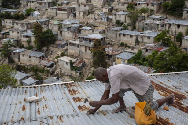 Antony Exilien secures the roof of his house in response to Tropical Storm Elsa, in Port-au-Prince, Haiti, on July 3, 2021. (Joseph Odelyn/AP Photo)