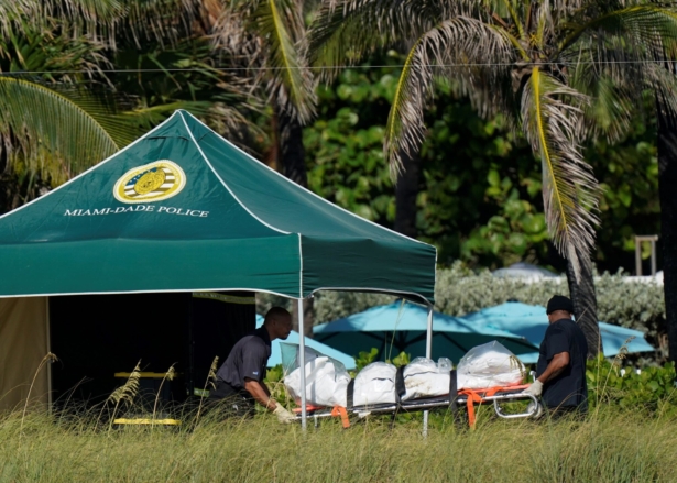 Workers transport a stretcher with remains extricated from the rubble, near the Champlain Towers South condo building, where scores of people remain missing more than a week after it partially collapsed, in Surfside, Fla., on July 2, 2021. (Mark Humphrey/AP Photo)