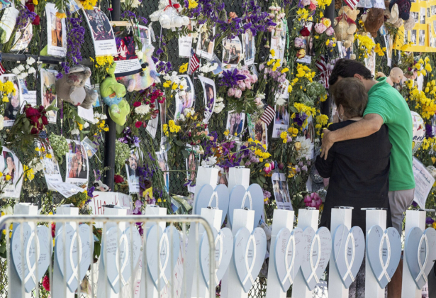 People mourn at the memorial wall for the victims of the Champlain Towers South collapse, in Surfside, Fla., on July 8, 2021. (Pedro Portal/Miami Herald via AP)