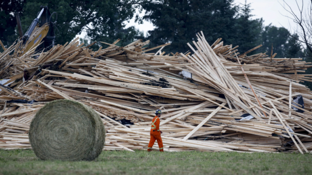 Crews work to clean up a spill after the derailment of a 20-car train carrying tar sands and lumber near Blackfalds, Alta., Canada, on July 3, 2021. (Jeff McIntosh/The Canadian Press via AP)